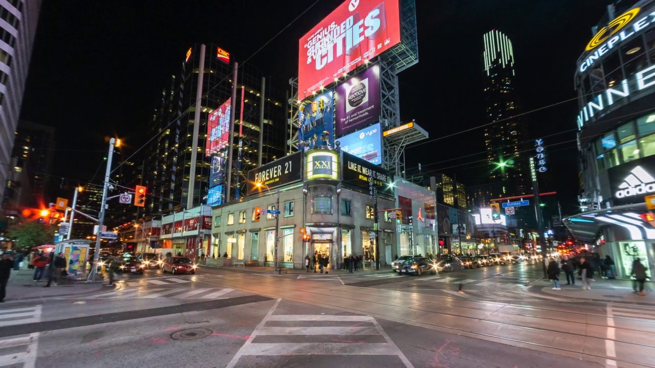 在繁忙的Yonge-Dundas十字路口在多伦多市中心，安大略省，加拿大的人和交通的夜间延时视图视频素材