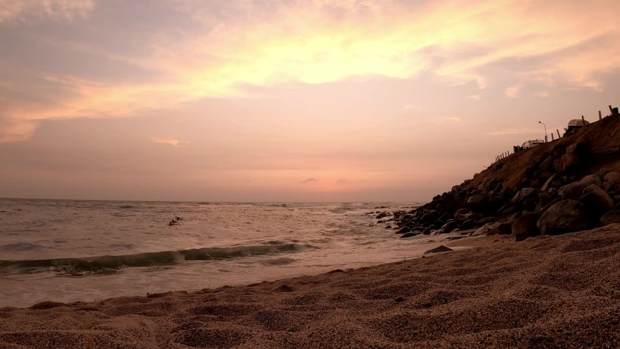 面目全非的冲浪者，孩子们走出大海，在沙滩上欣赏日落和地平线上的太阳的美丽景色视频素材