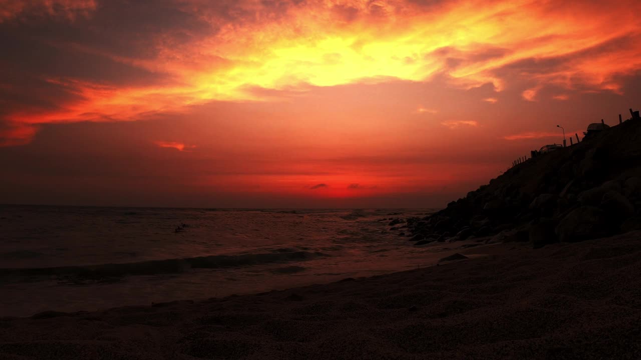 从沙滩上欣赏美丽的景色，海滩上的日落和海面上的太阳，冲浪者在4k游泳视频素材