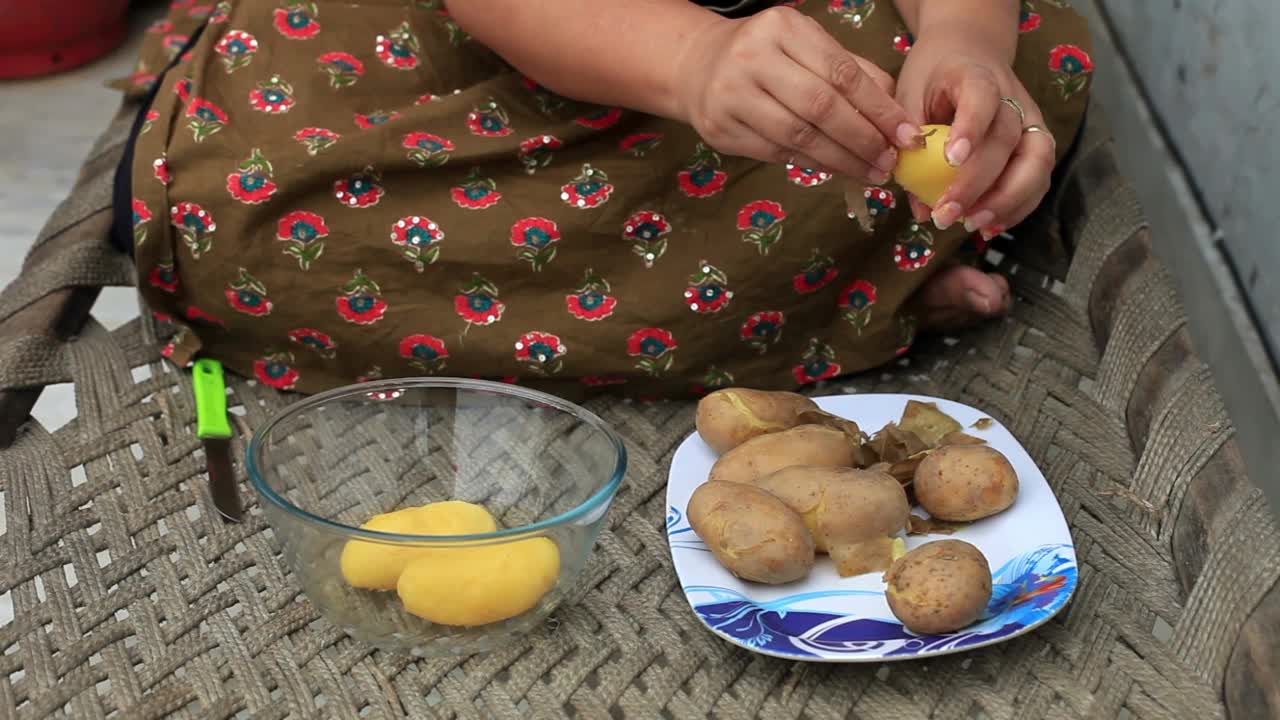 妇女在家里削土豆皮视频素材