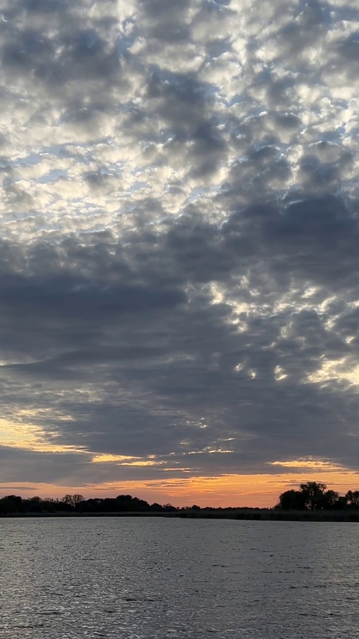 戏剧性的天空与云在河流的水。美丽明亮的橙色夕阳。视频素材