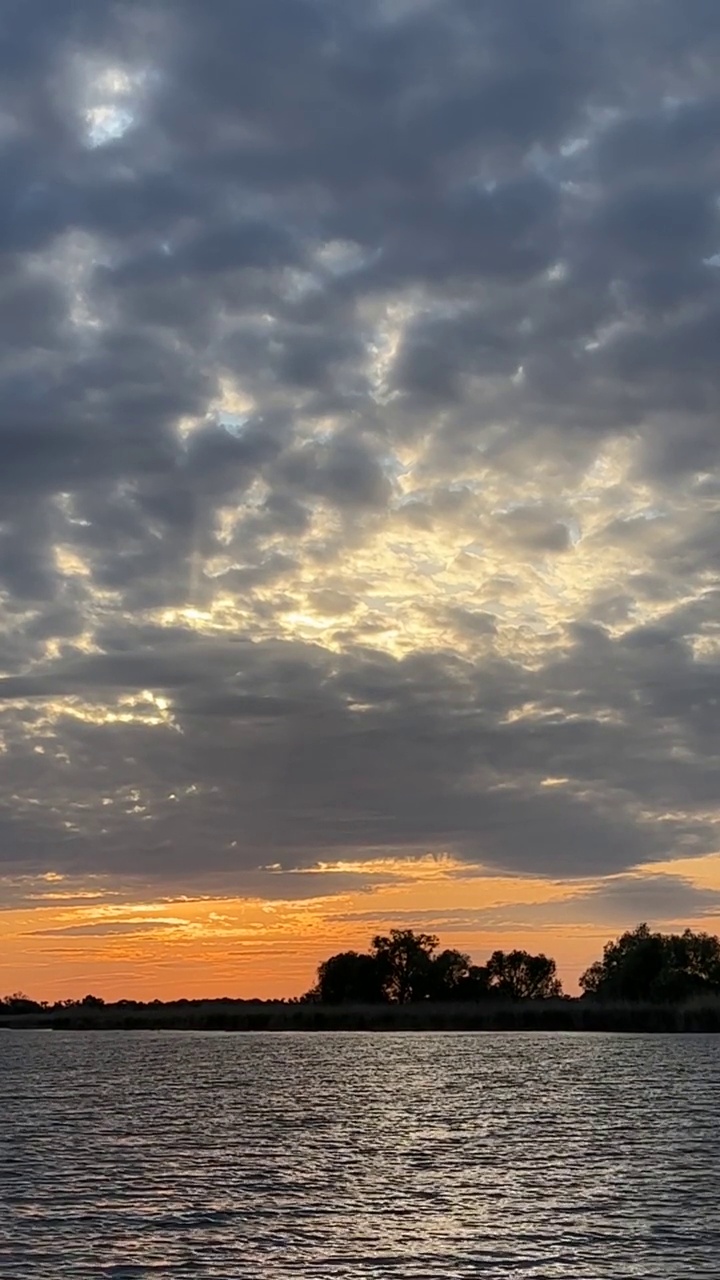 戏剧性的天空与云在河流的水。美丽明亮的橙色夕阳。视频素材