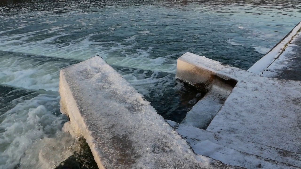 水库中河岸结冰的水流湍急的水库视频素材