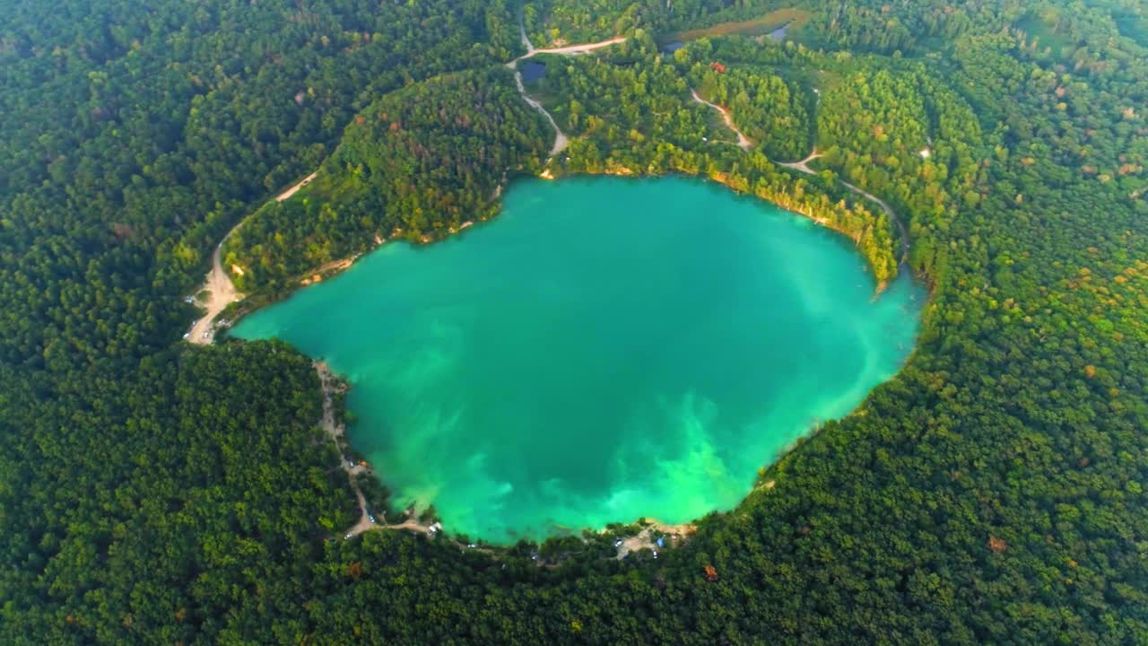 人工坑内蔚蓝色水景的航拍镜头。Cherepashyntsi采石场有沙质的河岸和山上茂密的森林。乌克兰的马尔代夫视频素材