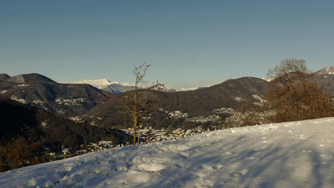 在一个阳光明媚的日子里，人散步和快乐的山景与雪和晴朗的蓝天视频素材