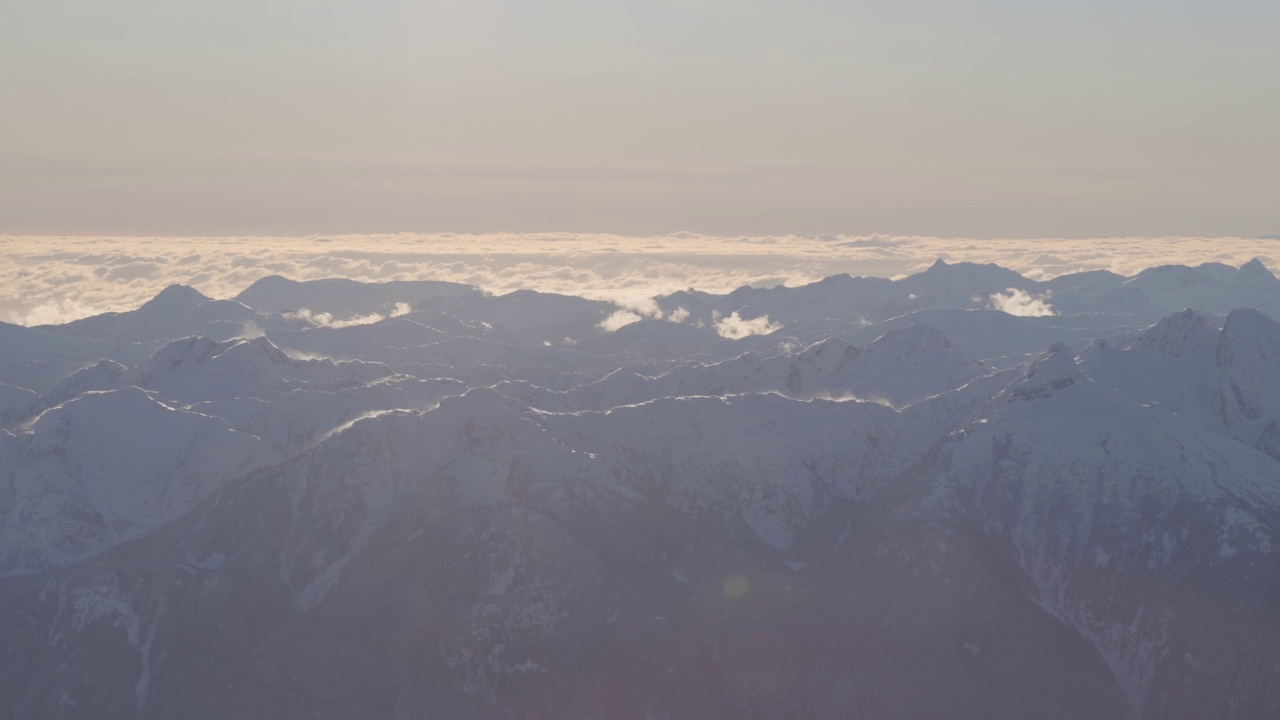 在阳光明媚的冬季，加拿大山被雪覆盖的空中全景视频素材