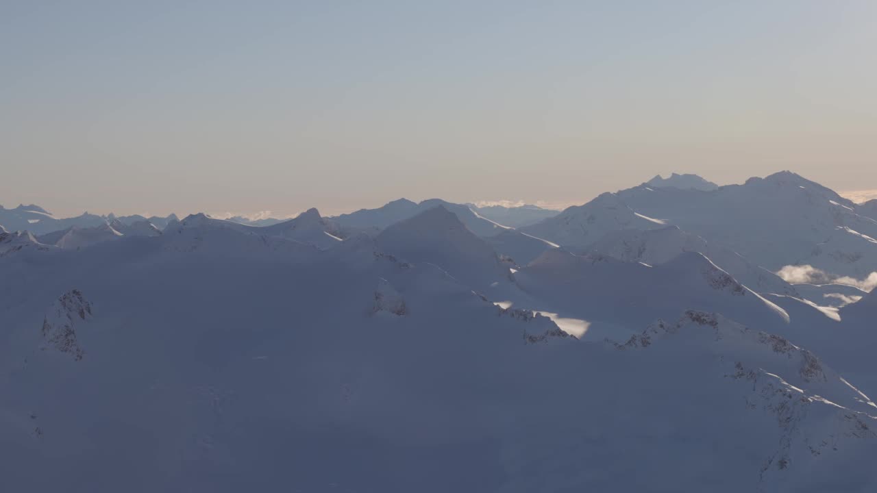 在阳光明媚的冬季，加拿大山被雪覆盖的空中全景视频素材