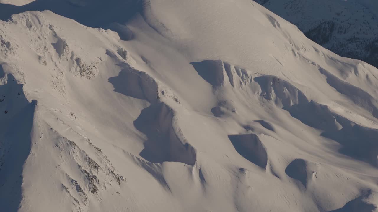 在阳光明媚的冬季，加拿大山被雪覆盖的空中全景视频素材