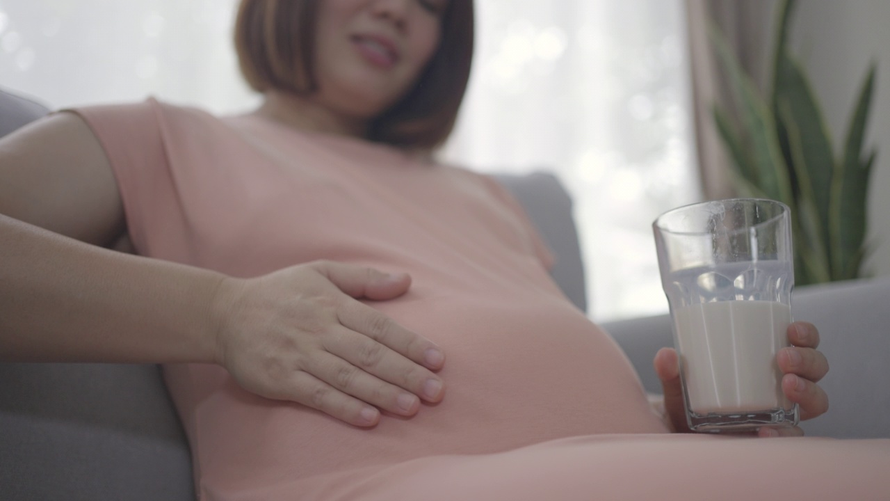 健康的亚洲孕妇喝牛奶保健婴儿在子宫内视频素材