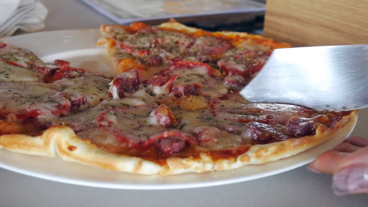 在餐厅的餐桌上用手拿着一片有弹性芝士的披萨视频下载