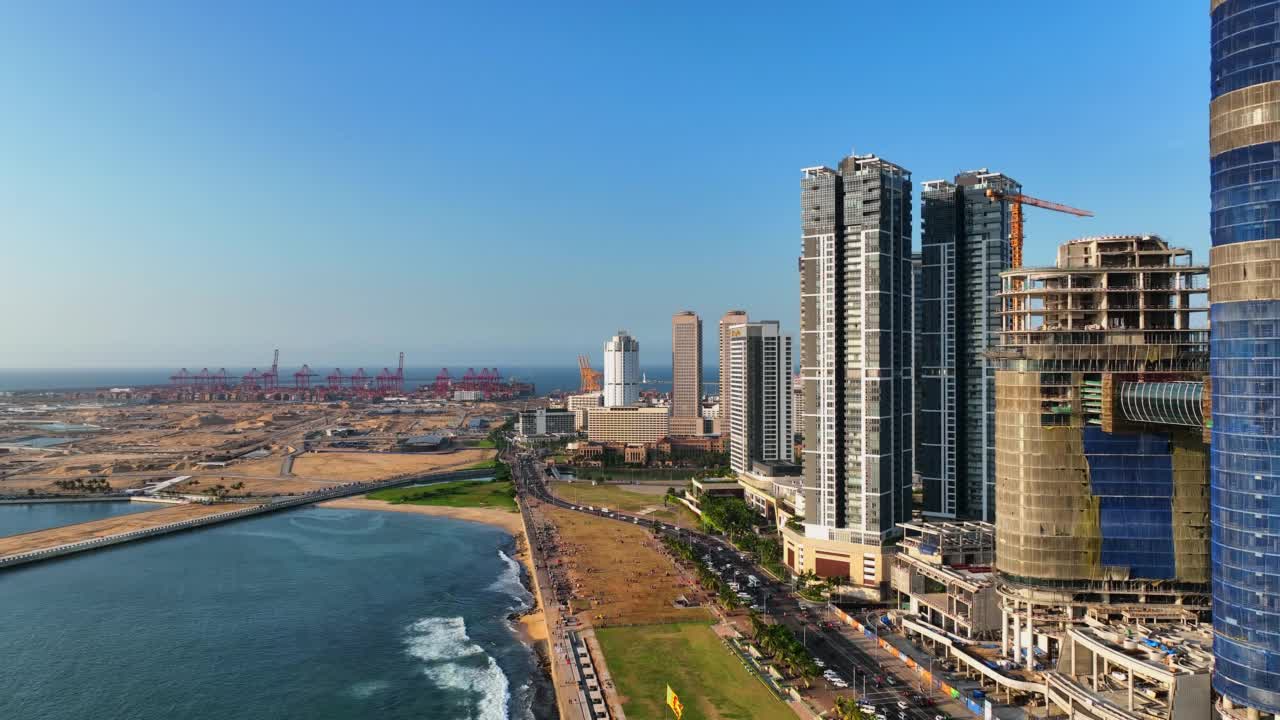 空中拍摄的现代高层建筑在阳光明媚的日子，无人机飞在海上在城市-科伦坡，斯里兰卡视频素材