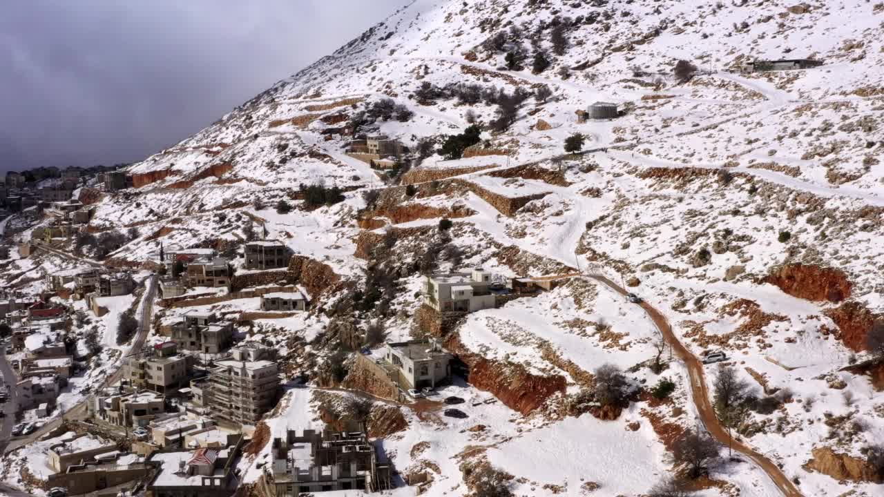 在多云天空下的雪域高原上的房屋的空中向前拍摄-以色列戈兰视频素材