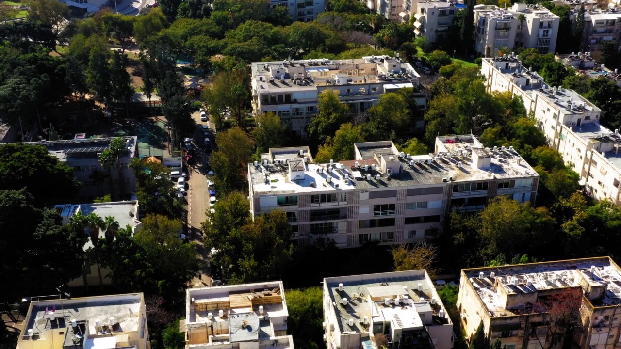 空中平移拍摄的白色建筑在城市的树木中，无人机飞越露台-特拉维夫亚福，以色列视频素材