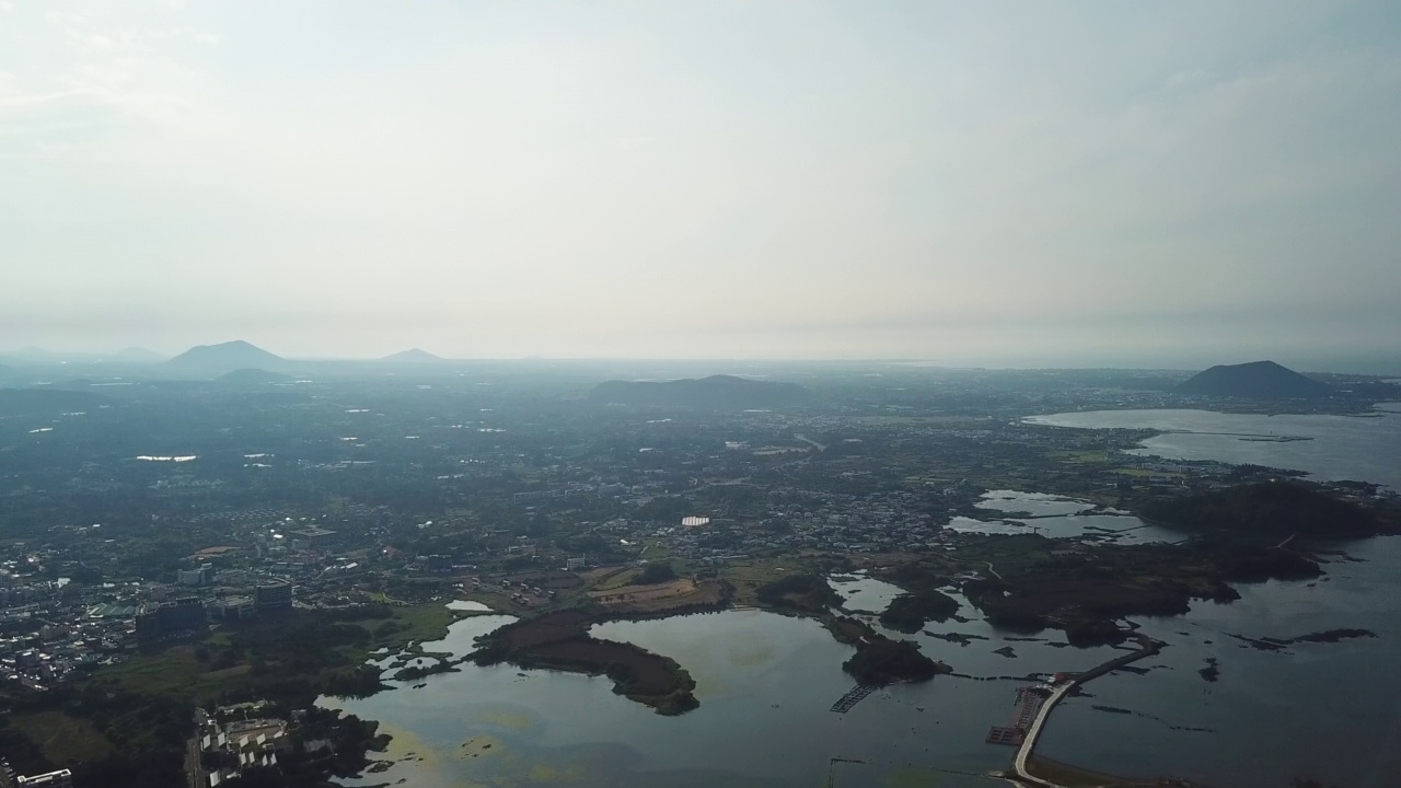 村庄，山，火山锥，海洋-圣山郡和五草浦港在九州郡/西归浦市和济州市，济州岛，韩国视频素材