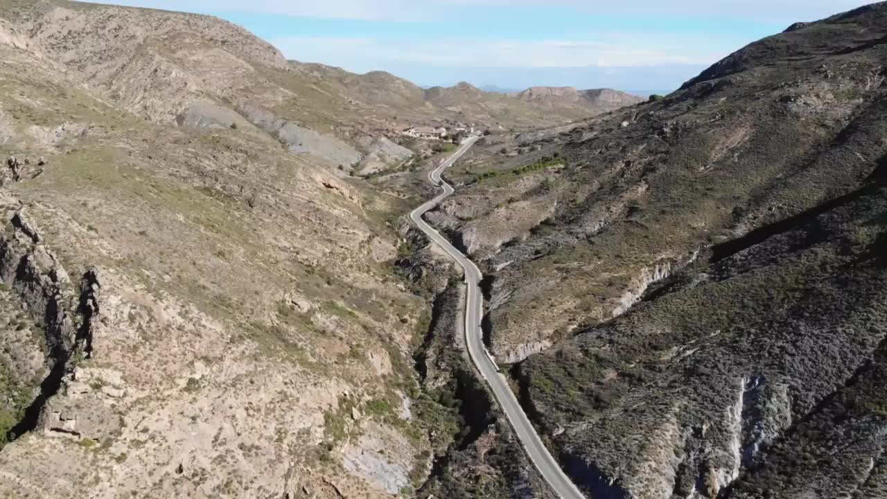 在一个阳光明媚的日子里，山间马鞍上的公路鸟瞰图视频素材