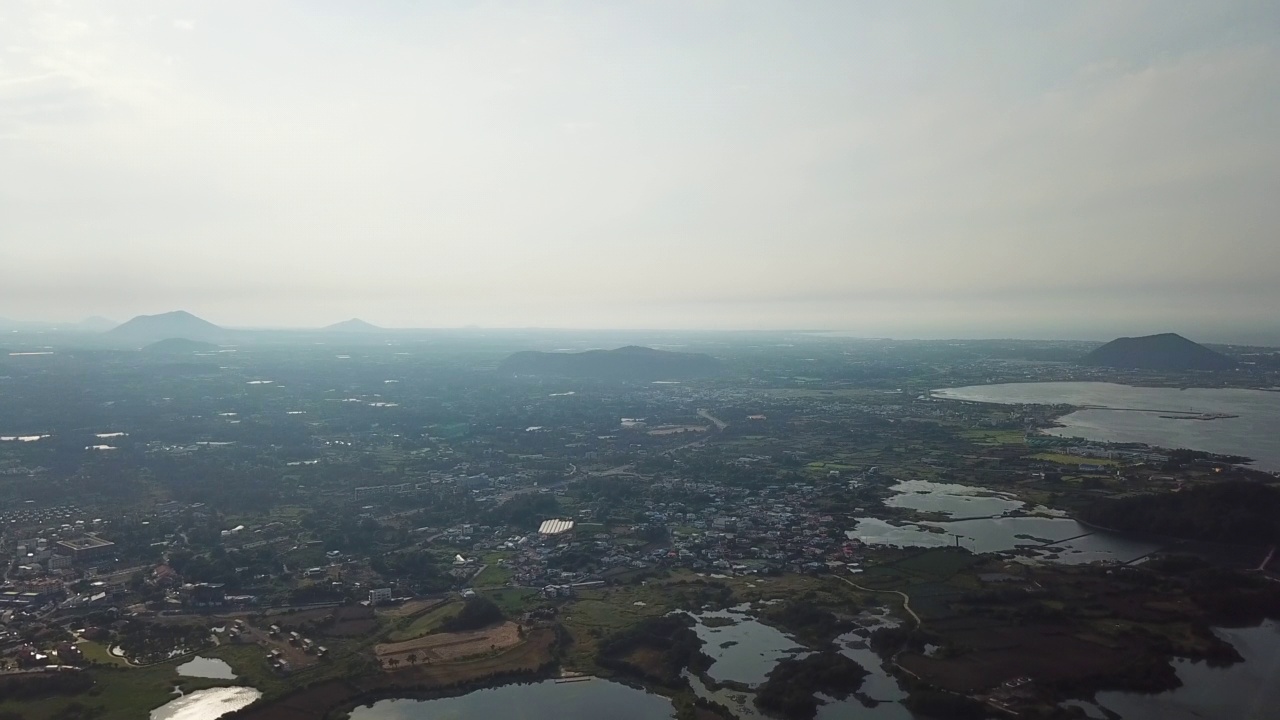 村庄，山，火山锥，海洋-圣山郡和五草浦港在九州郡/西归浦市和济州市，济州岛，韩国视频素材