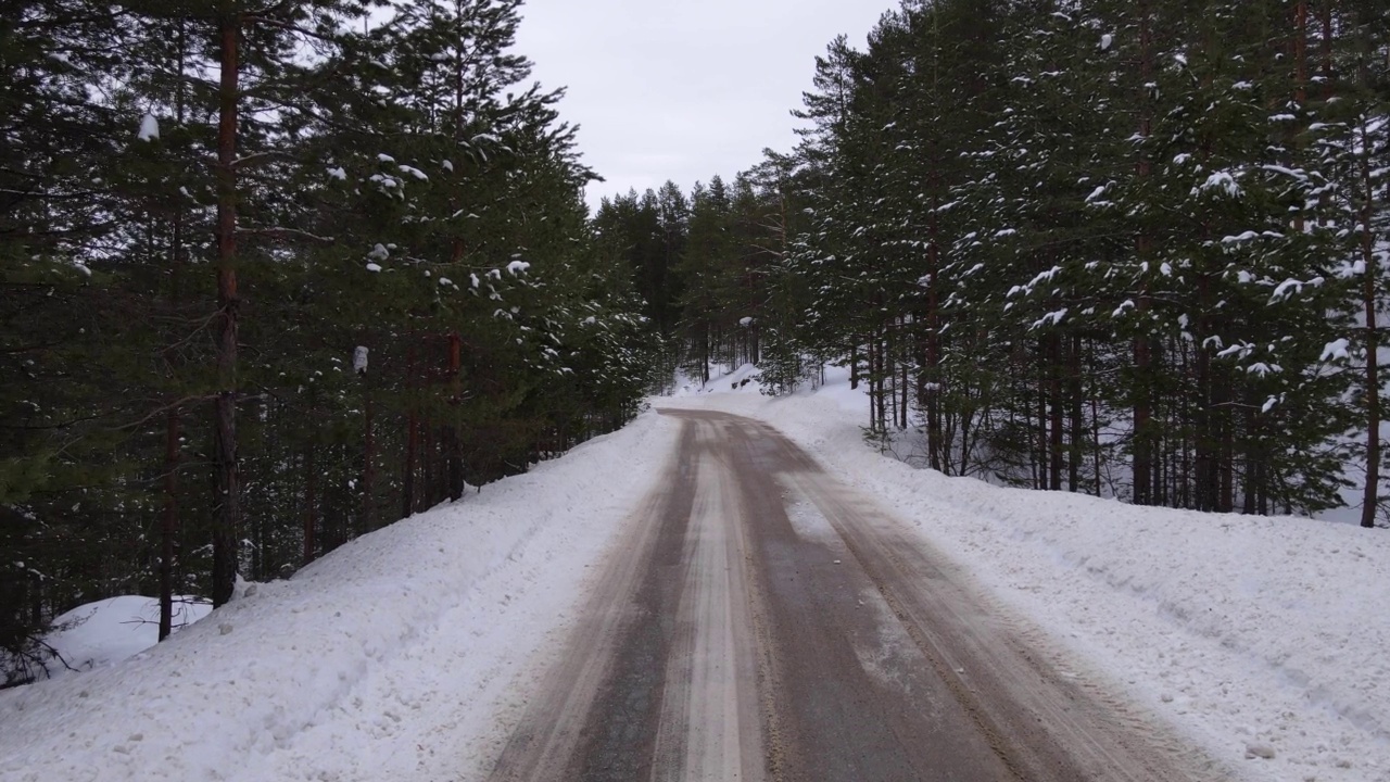 冬天雪路在林间结霜的针叶树之间。冬季山口景观视频下载