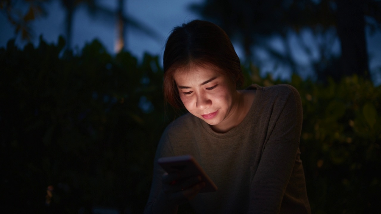 一个女人在海滩上用手机视频素材