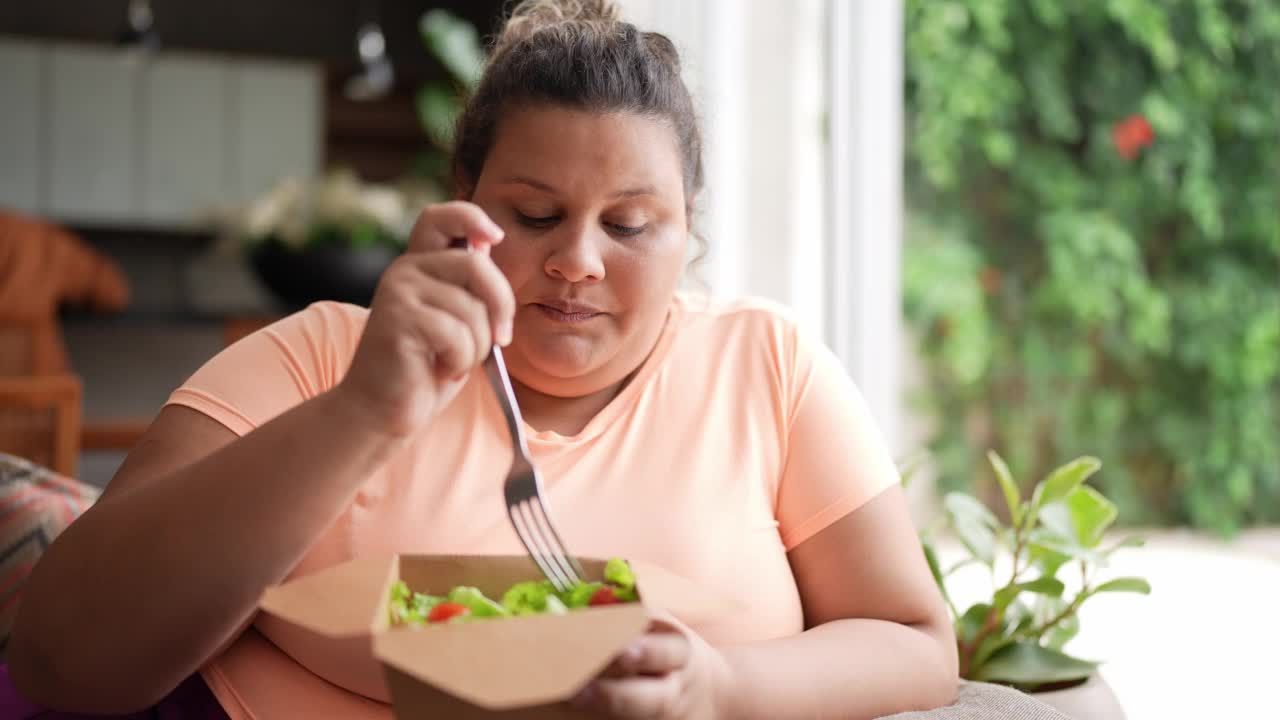 中年妇女在家里吃饭时透过窗户看视频素材