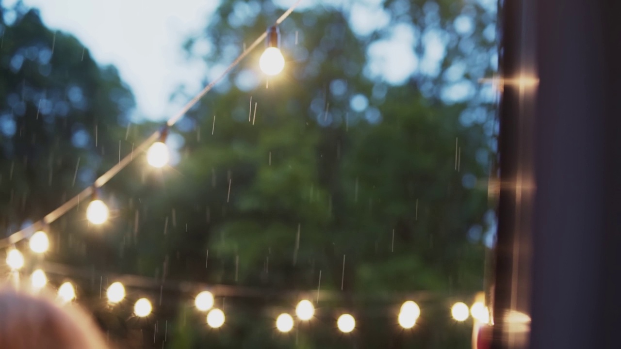 傍晚的大雨映衬着复古的灯花环视频素材