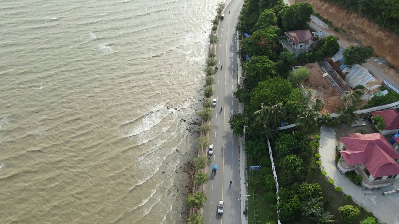 在大风天，无人机拍摄了海岸公路上的海浪视频素材