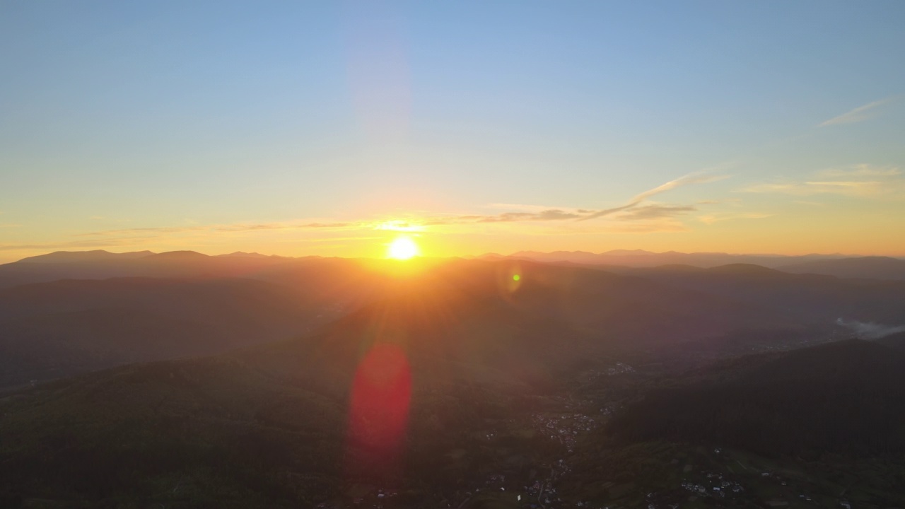 鸟瞰日落时明亮的太阳和黑暗的小山。傍晚朦胧的山峰和朦胧的山谷视频素材