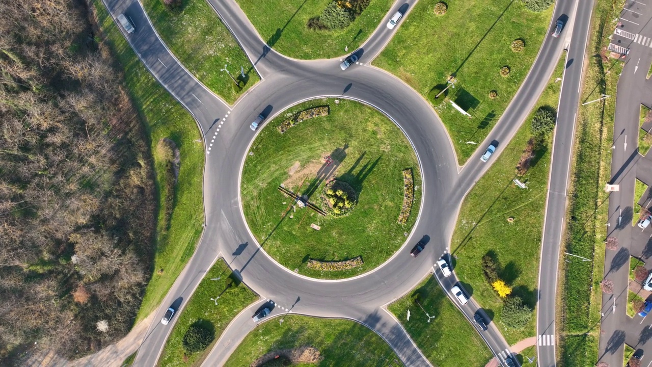 快速移动的繁忙交通的道路回旋交叉路口鸟瞰图。城市环形交通十字路口视频素材