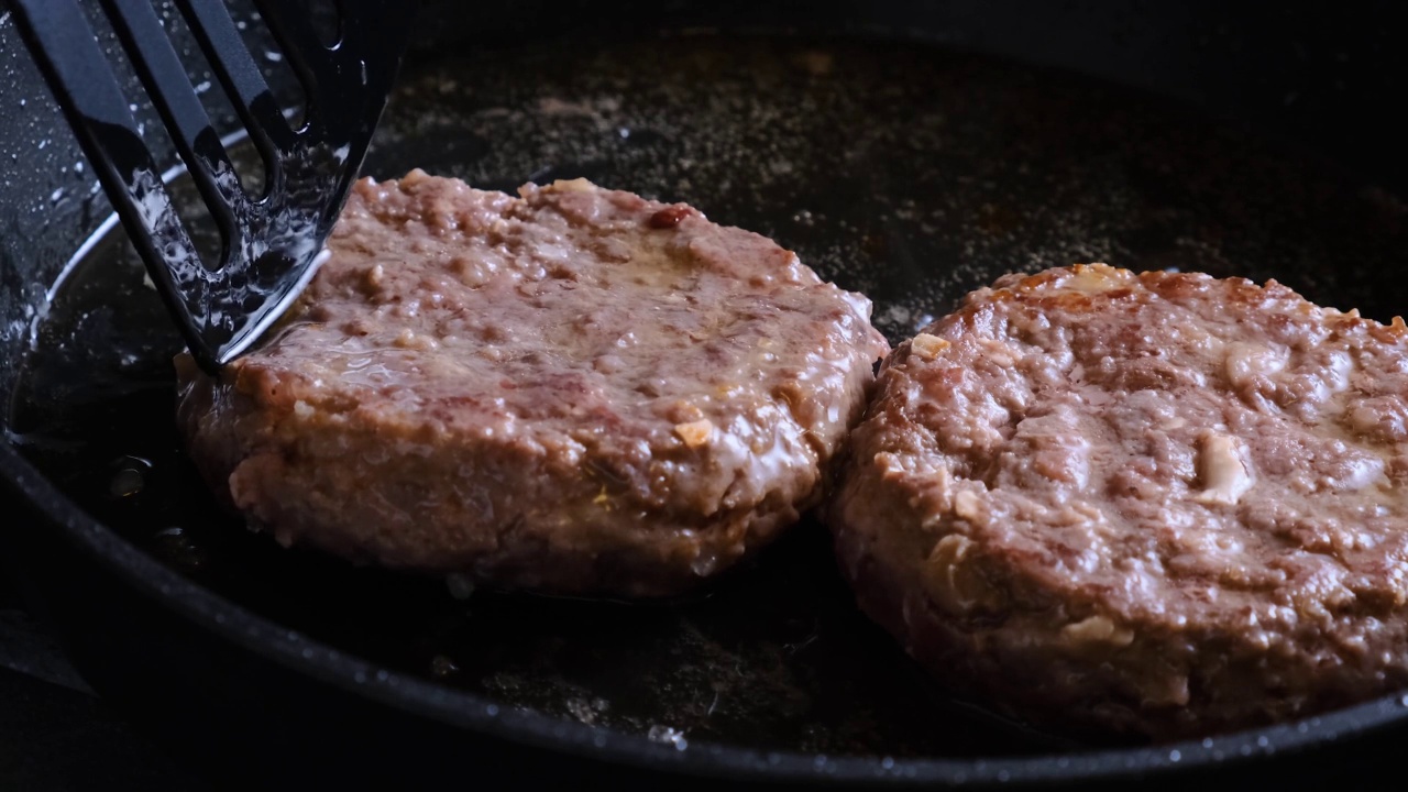 在煎锅里翻翻肉饼。准备食物视频素材