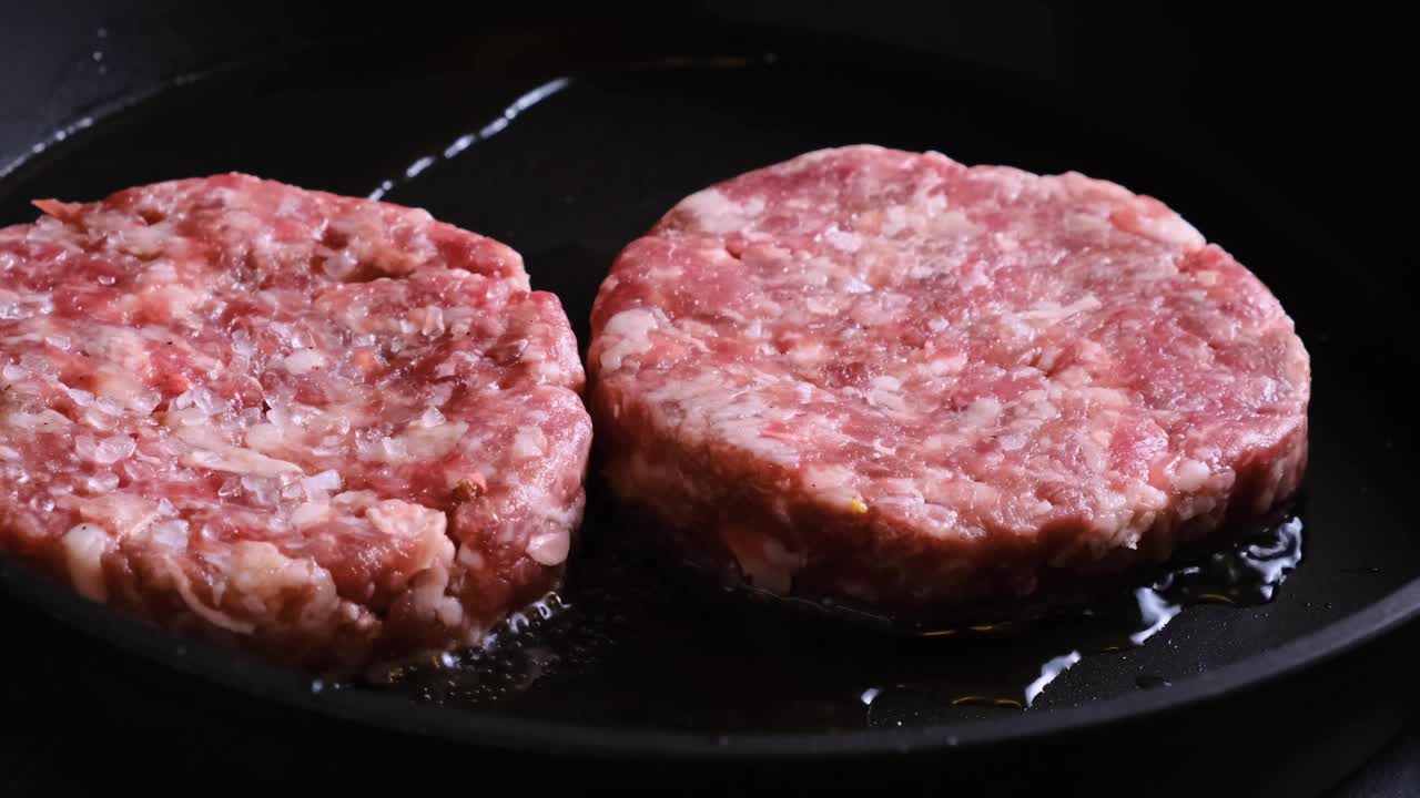 在煎锅里煮牛肉饼。准备食物视频素材