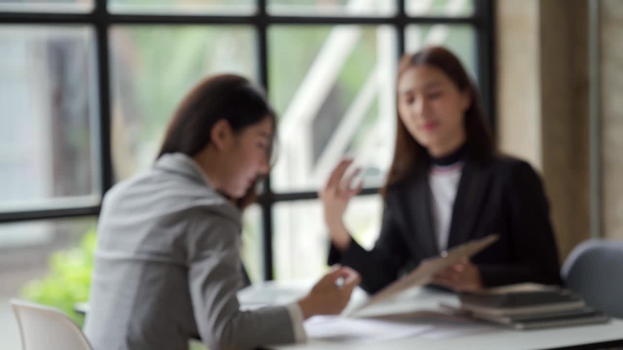 亚洲女领导在会议上用电脑教学指导业务团队，女高管解释在线项目谈话，帮助年轻同事在办公室咨询客户。视频素材