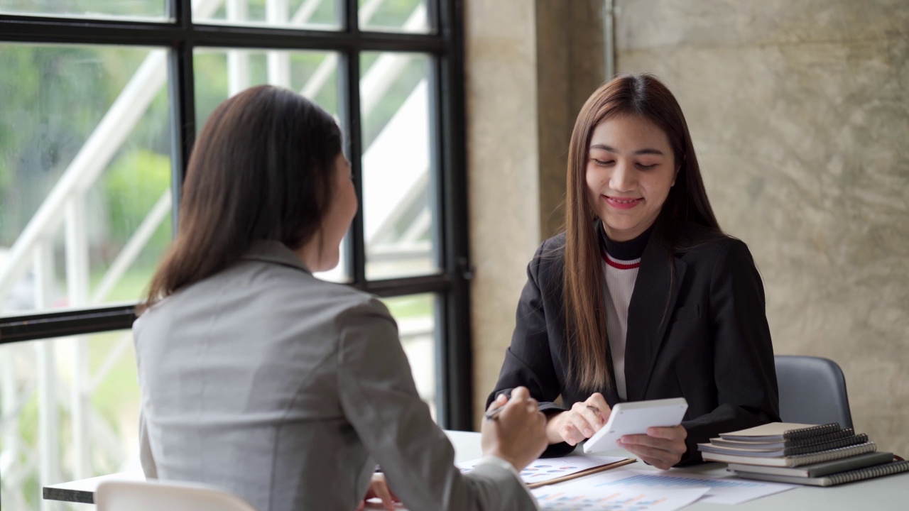 亚洲女领导在会议上用电脑教学指导业务团队，女高管解释在线项目谈话，帮助年轻同事在办公室咨询客户。视频素材