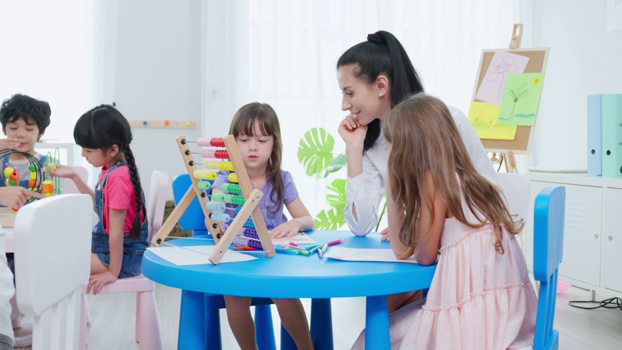 白种人美女老师在学校给孩子上课。幼稚园迷人的女教师大师在课堂上用有趣的活动讲解教育孩子们的学生。视频素材