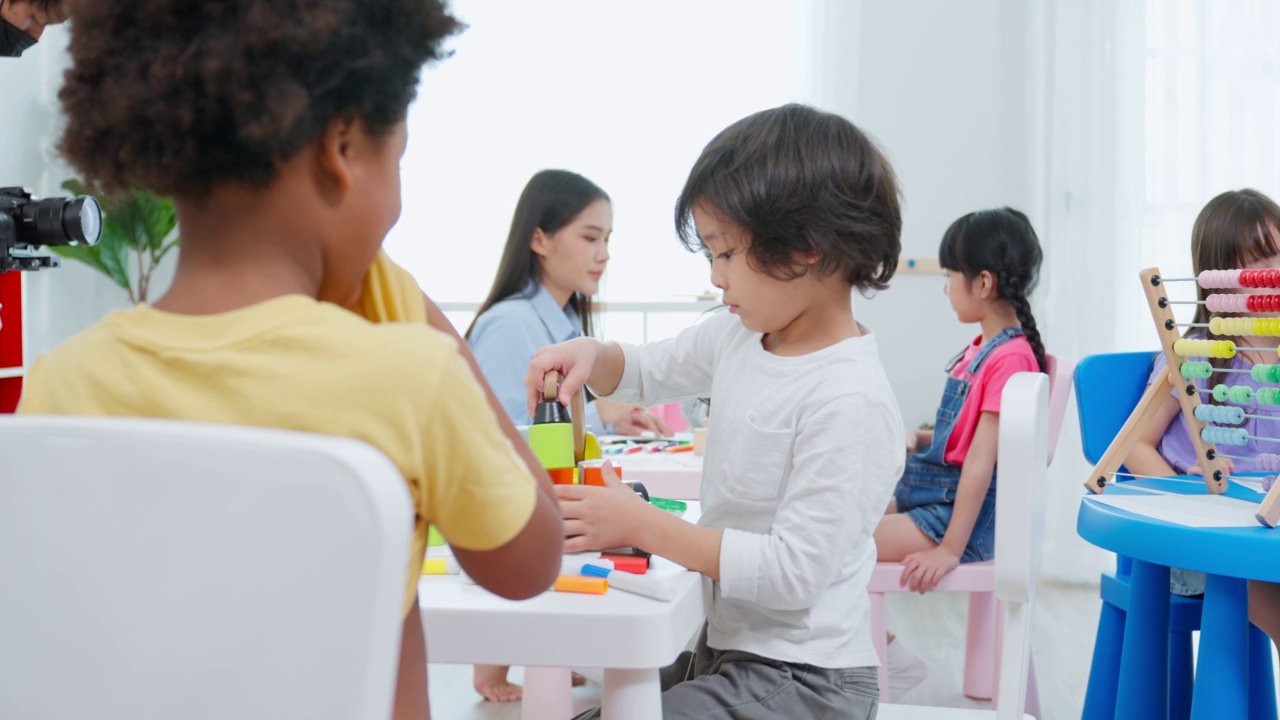 亚洲美丽的年轻女子老师在学校给孩子上课。魅力四射的女教师老师在幼稚园的课堂上用有趣的活动讲解和教育孩子们视频素材