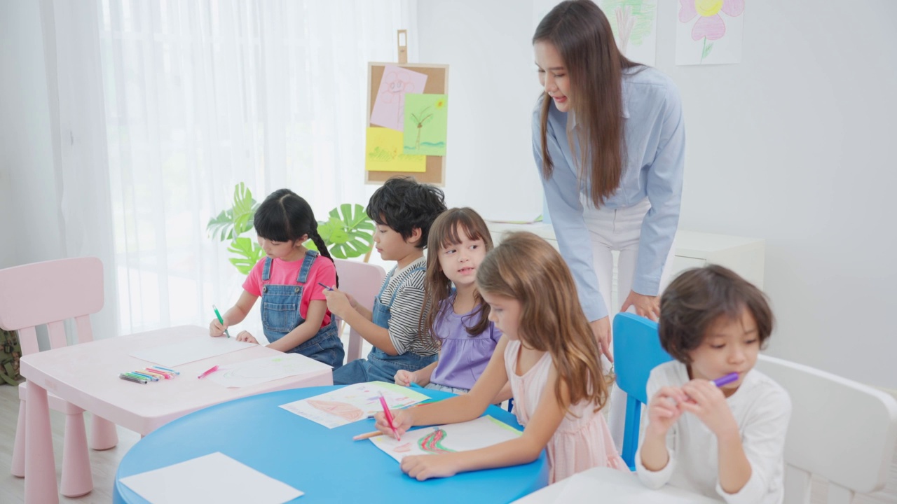 亚洲美丽的年轻女子老师在学校给孩子上课。魅力四射的女教师老师在幼稚园的课堂上用有趣的活动讲解和教育孩子们视频素材