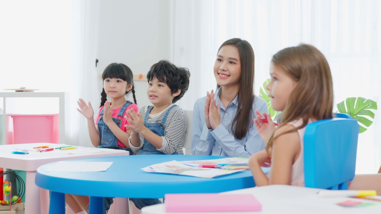 亚洲美丽的年轻女子老师在学校给孩子上课。魅力四射的女教师老师在幼稚园的课堂上用有趣的活动讲解和教育孩子们视频素材