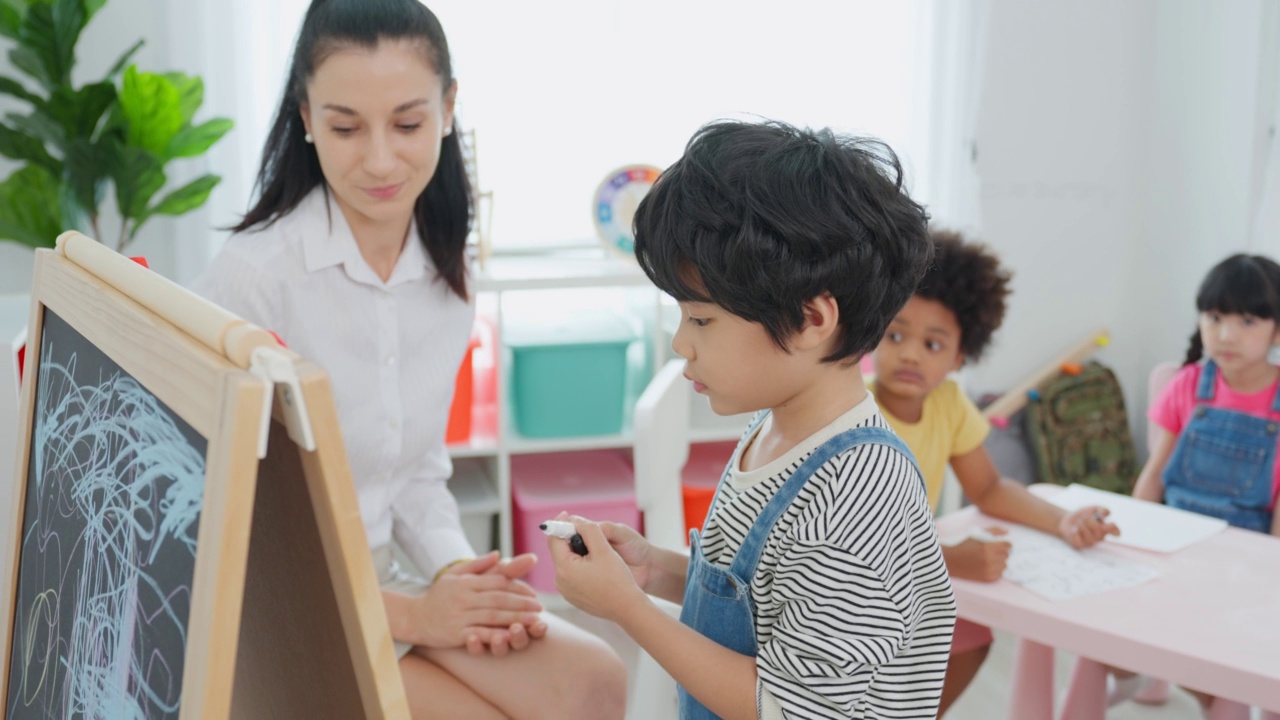 白种人美女老师在学校给孩子上课。幼稚园迷人的女教师大师在课堂上用有趣的活动讲解教育孩子们的学生。视频素材