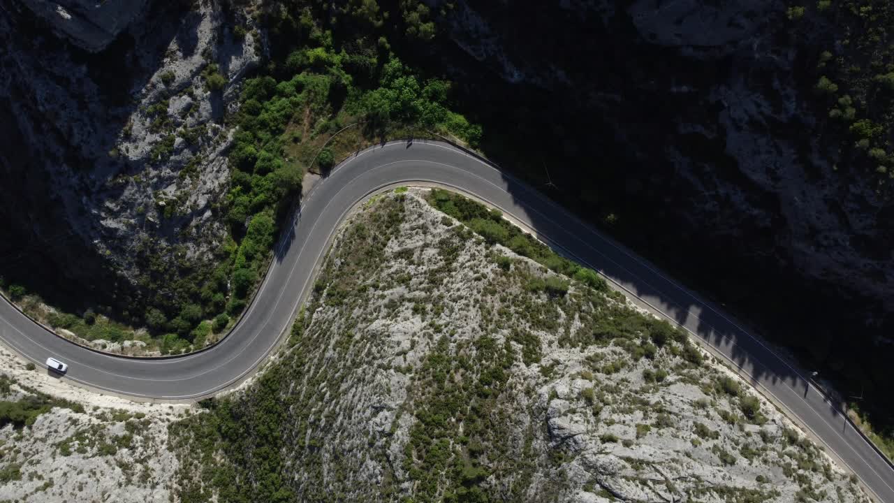 鸟瞰图，汽车和卡车行驶在弯曲的山路上。视频素材