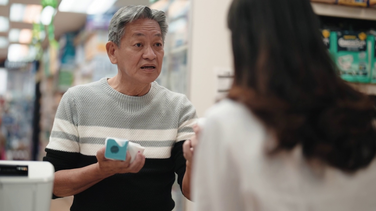 亚洲华人老年男子在药店向女药剂师寻求医疗用品方面的建议视频素材