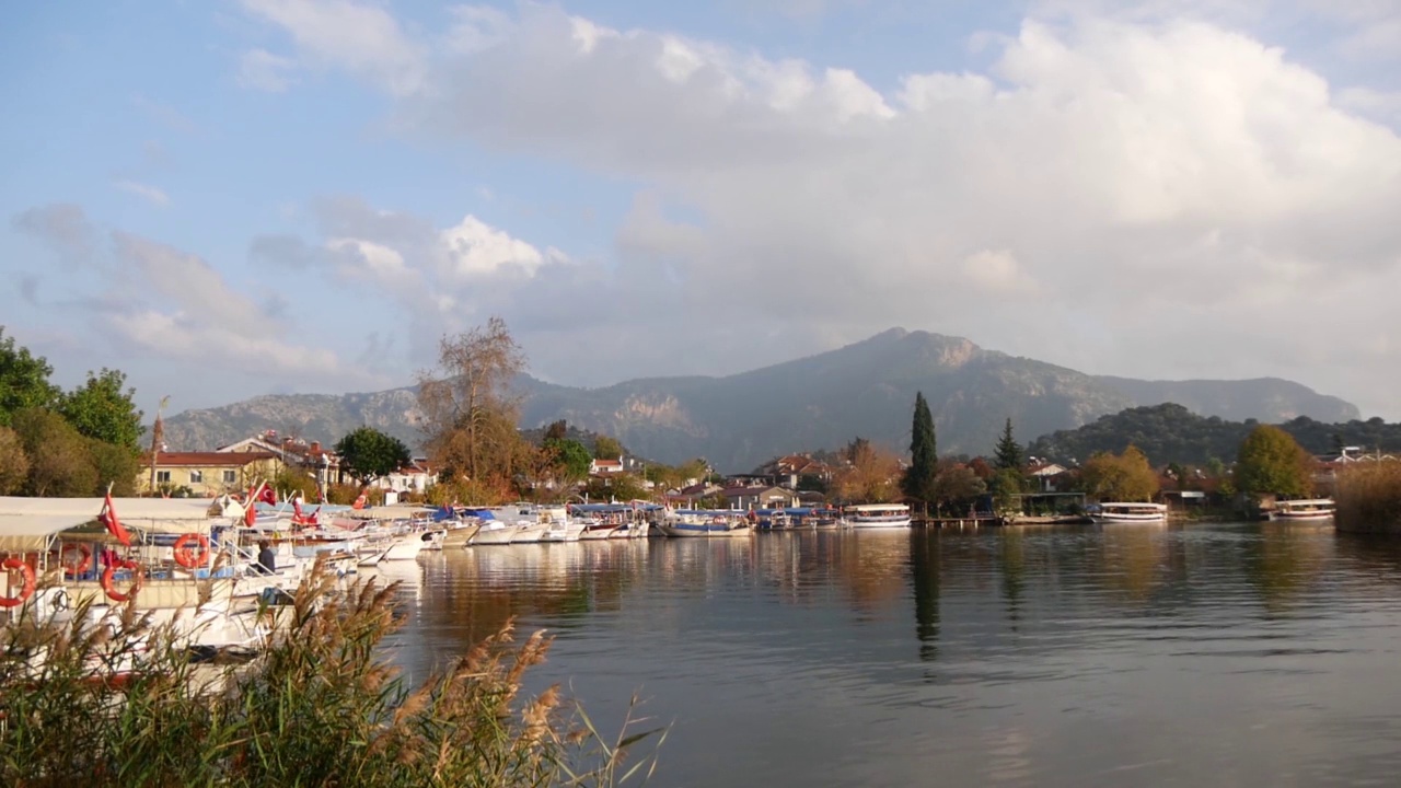 土耳其里维埃拉小镇(Dalyan)，平静的河流和许多船只的景色视频素材