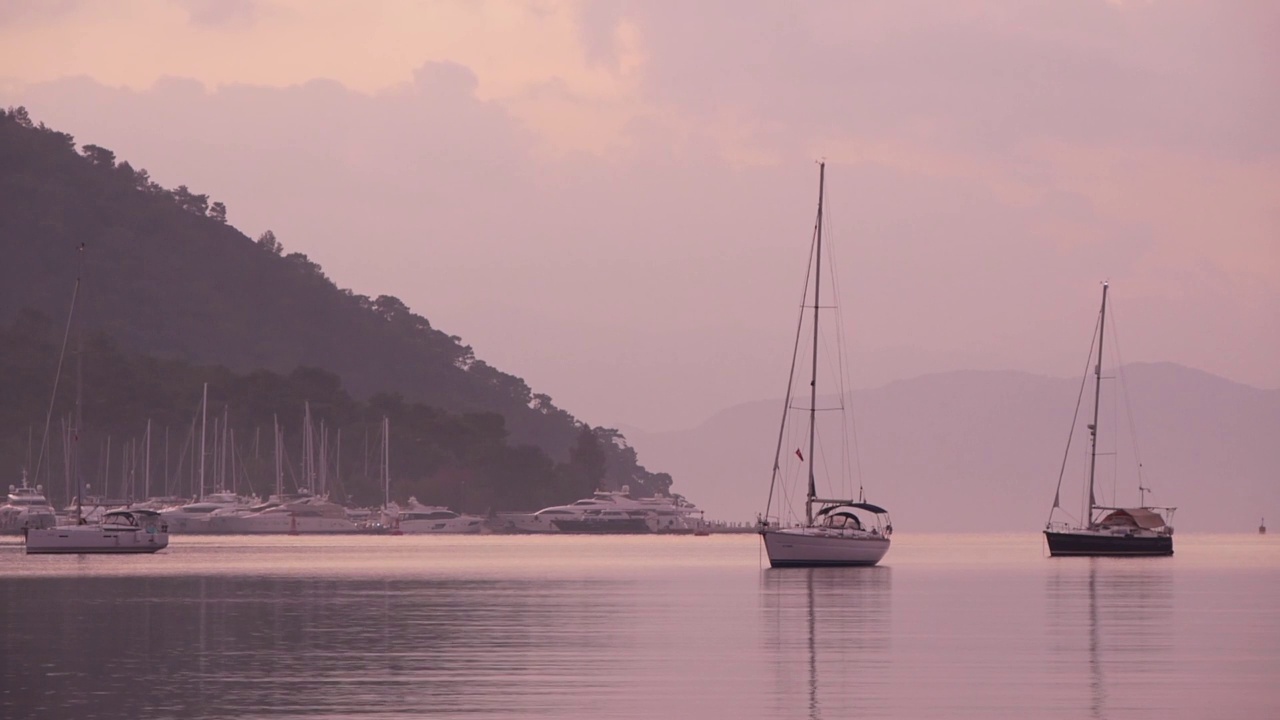 海湾与停泊的游艇和雾中的山岸的观点视频素材