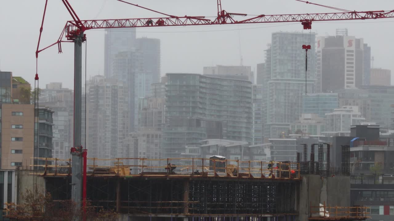 下雨的温哥华市中心，建筑工人们在用起重机延时拍摄视频素材