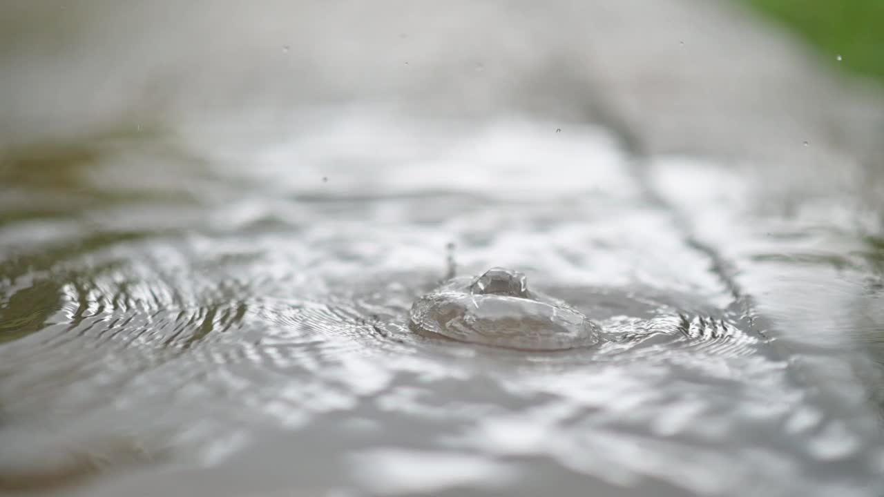 水滴慢慢地滴入水中。视频素材