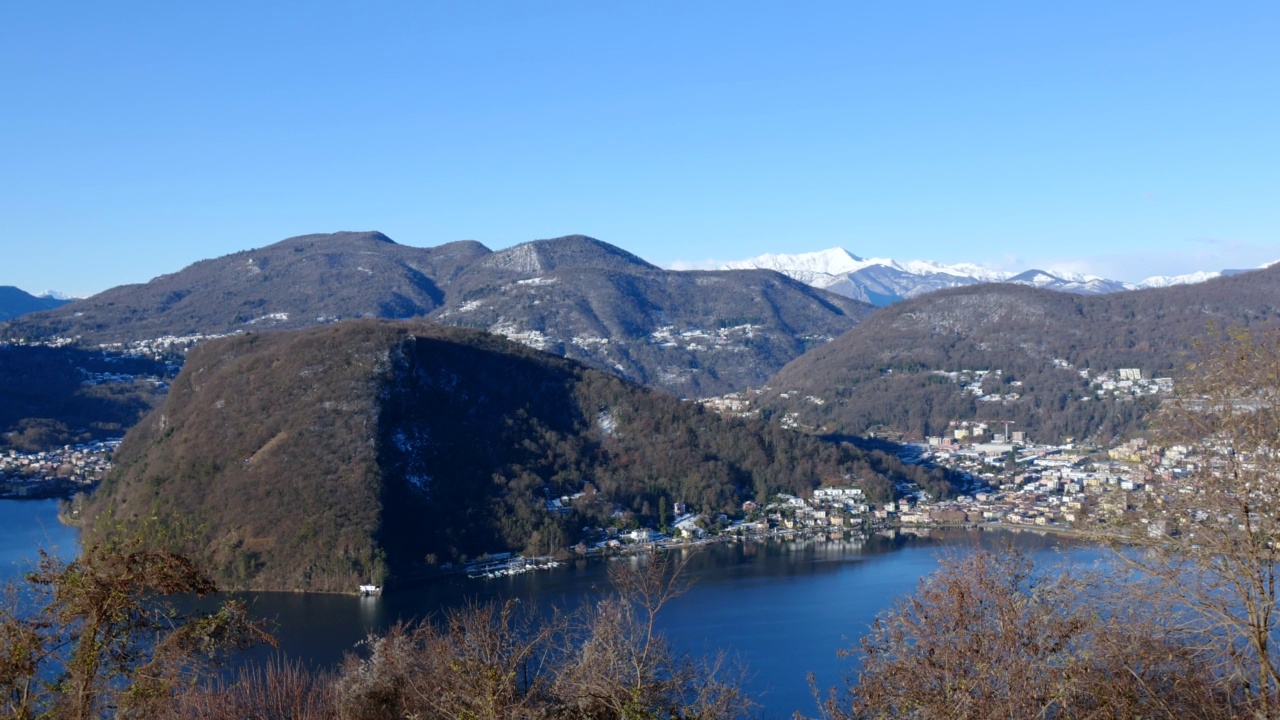 拉维纳城在蓬特特雷萨和卡斯拉诺与卢加诺湖和山景与雪和晴朗的蓝天晴天视频素材