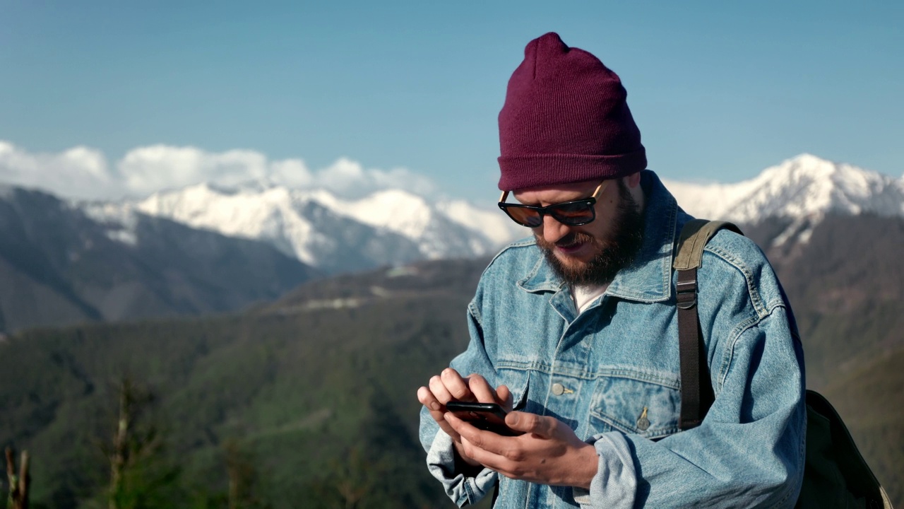 潮男旅行者规划旅游路线电子地图智能手机应用雪山视频素材