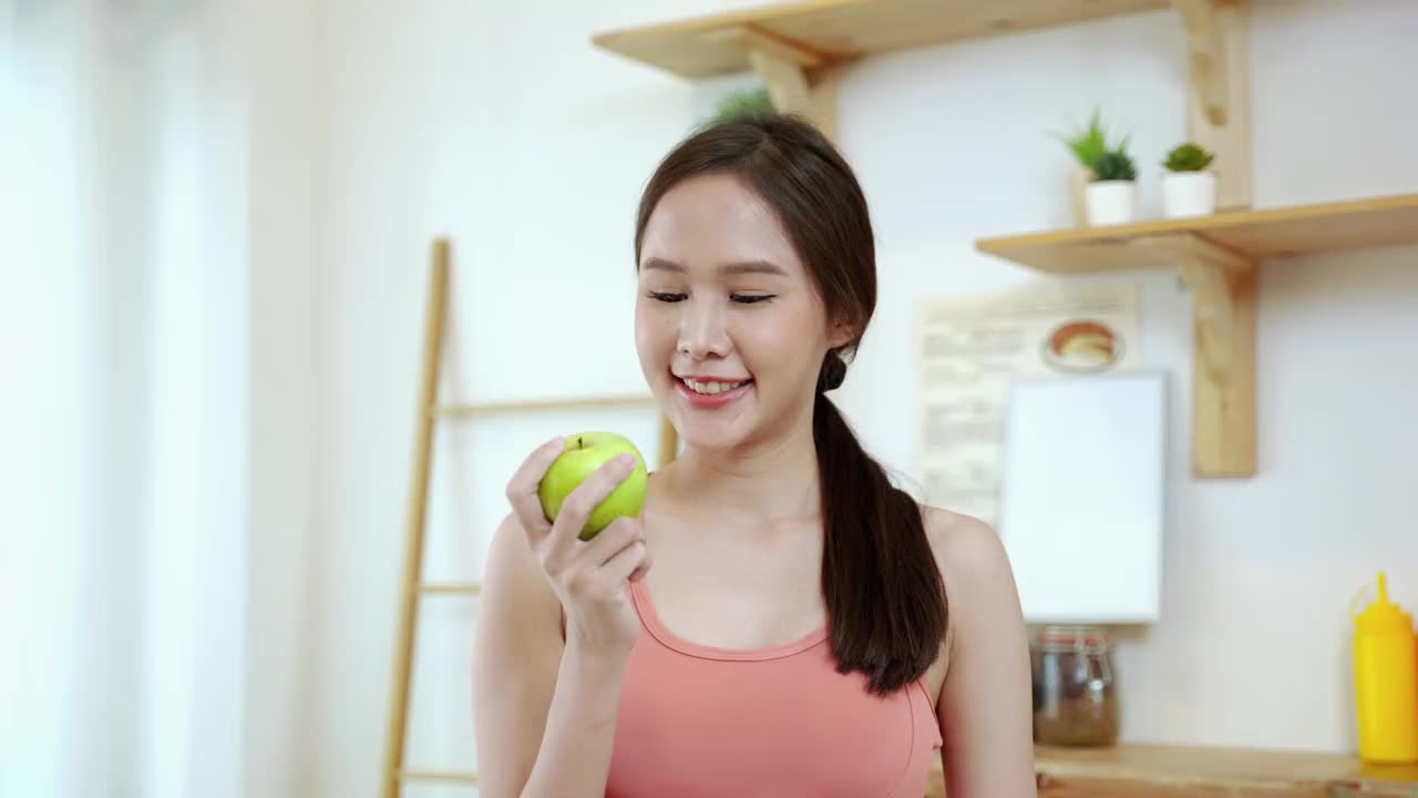 肖像，运动美亚洲美女正邀请吃苹果水果作为一种健康食品，减肥理念，健康饮食，保健。视频素材