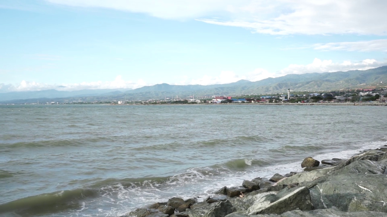 海浪冲击着多石的海岸。海浪拍打着岸边的石头，溅起水花。视频素材