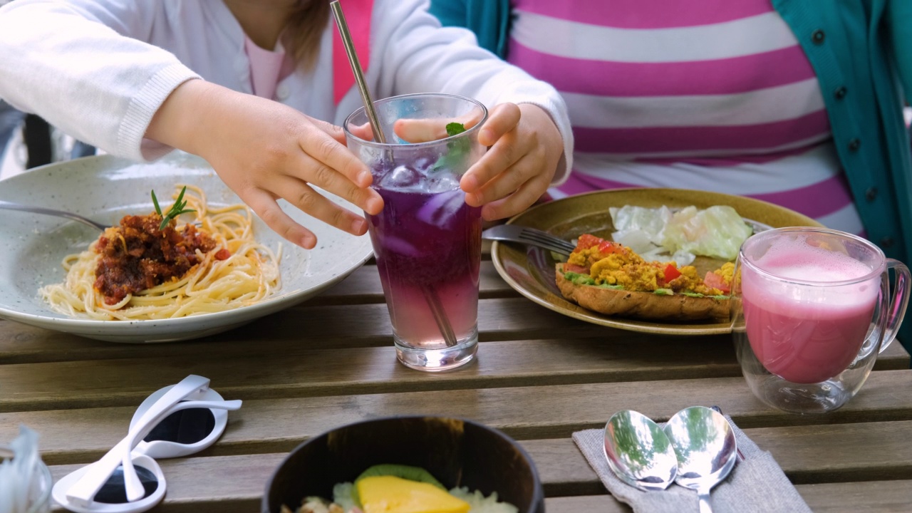 孩子喝柠檬水，妈妈喝粉色拿铁视频素材