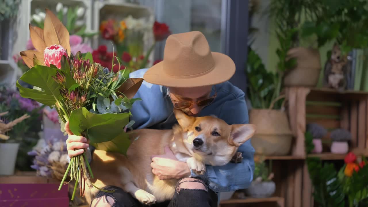 戴着墨镜和花束帽子的男人还有柯基犬，4k视频素材