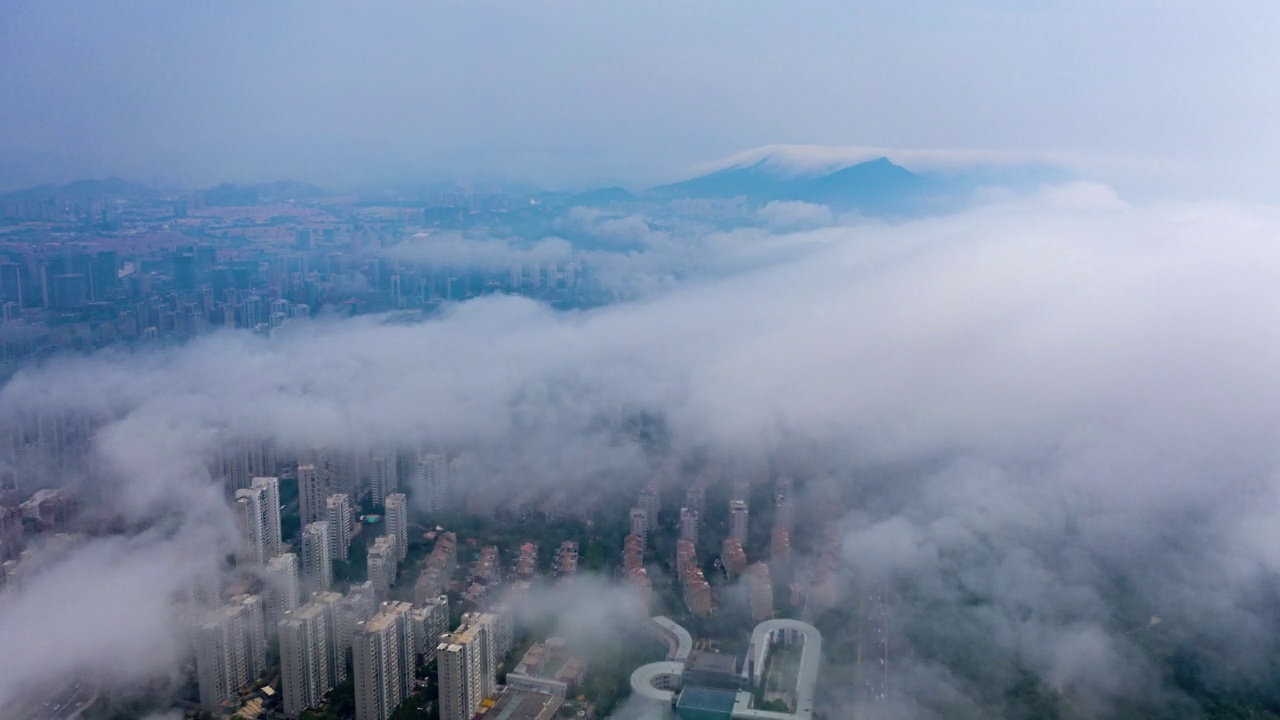 4K分辨率快速运动延时。雾中青岛市的无人机视角视频素材