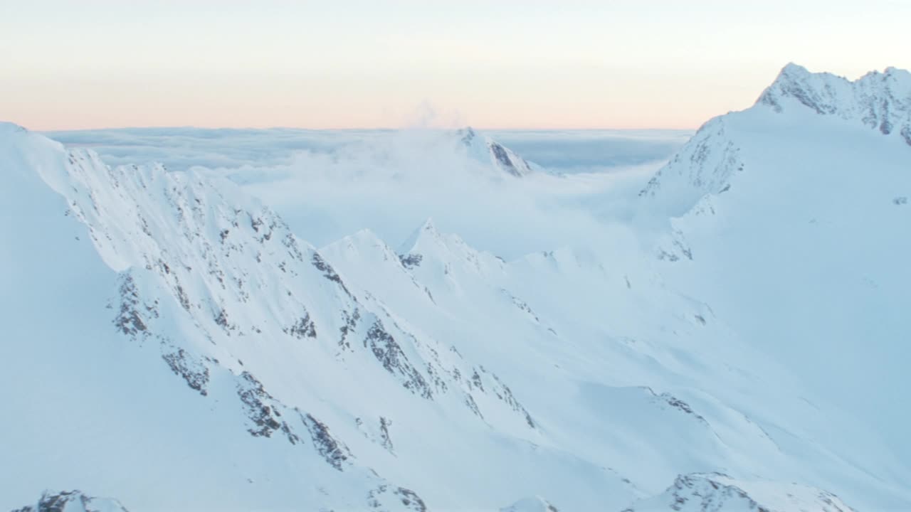 白雪皑皑的山峰和云层的鸟瞰图视频素材